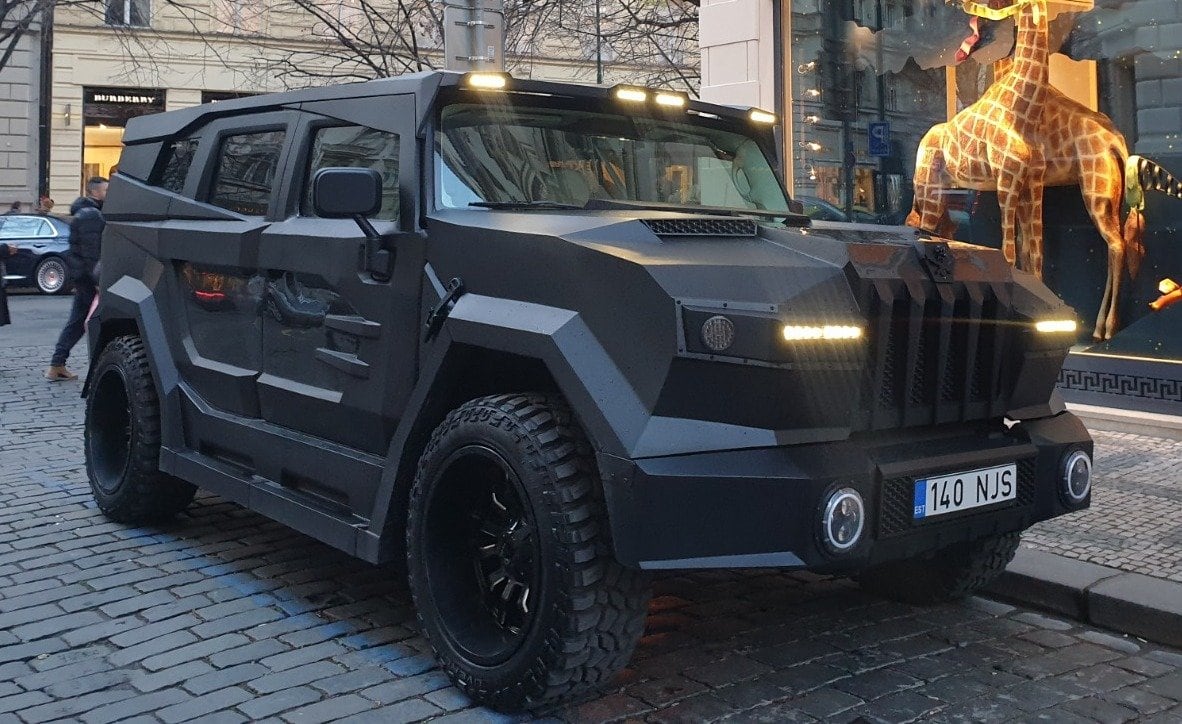 The DARTZ Prombron’ Black Stallion, a square black armoured BOND, parked on a cobbled city street