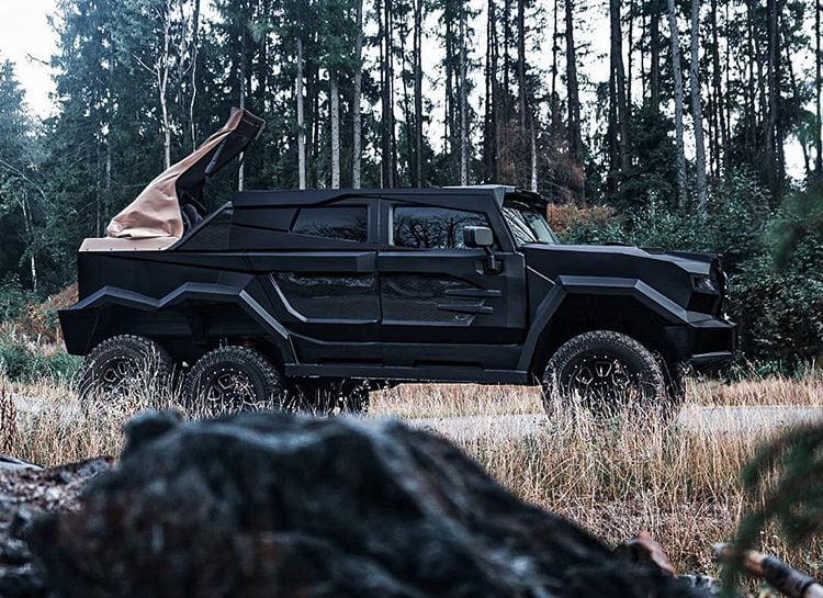 The six-wheeled DARTZ Royal Landaulet with its soft top folded, in a pine forest