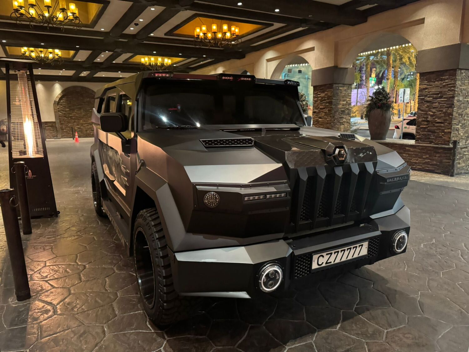 A matte black DARTZ Prombron’ Black Stallion under the chandeliers of a Las Vegas hotel porte-cochère