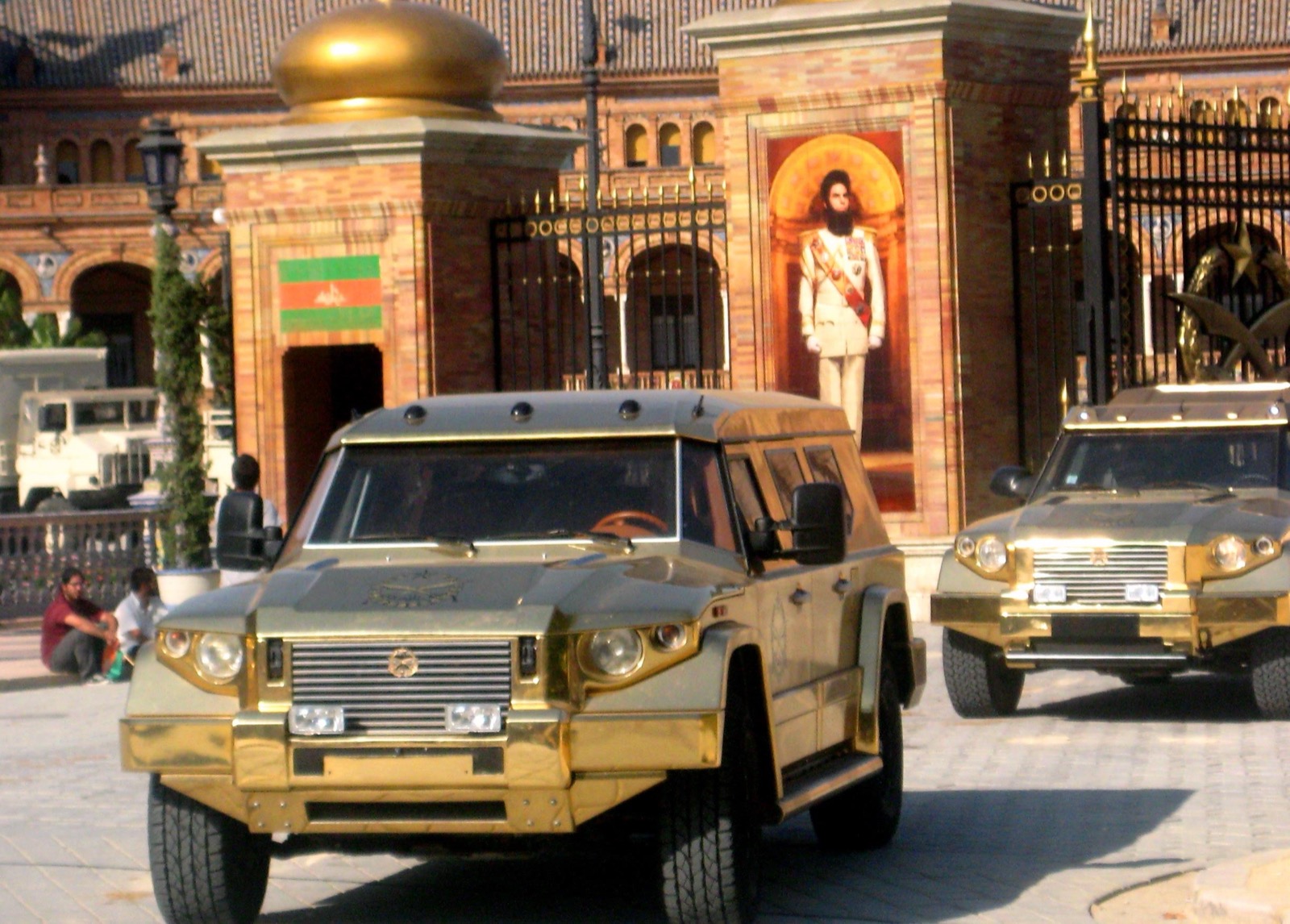 Gold DARTZ Prombron’ Aladeen Edition cars in front of a palace gate dressed for The Dictator