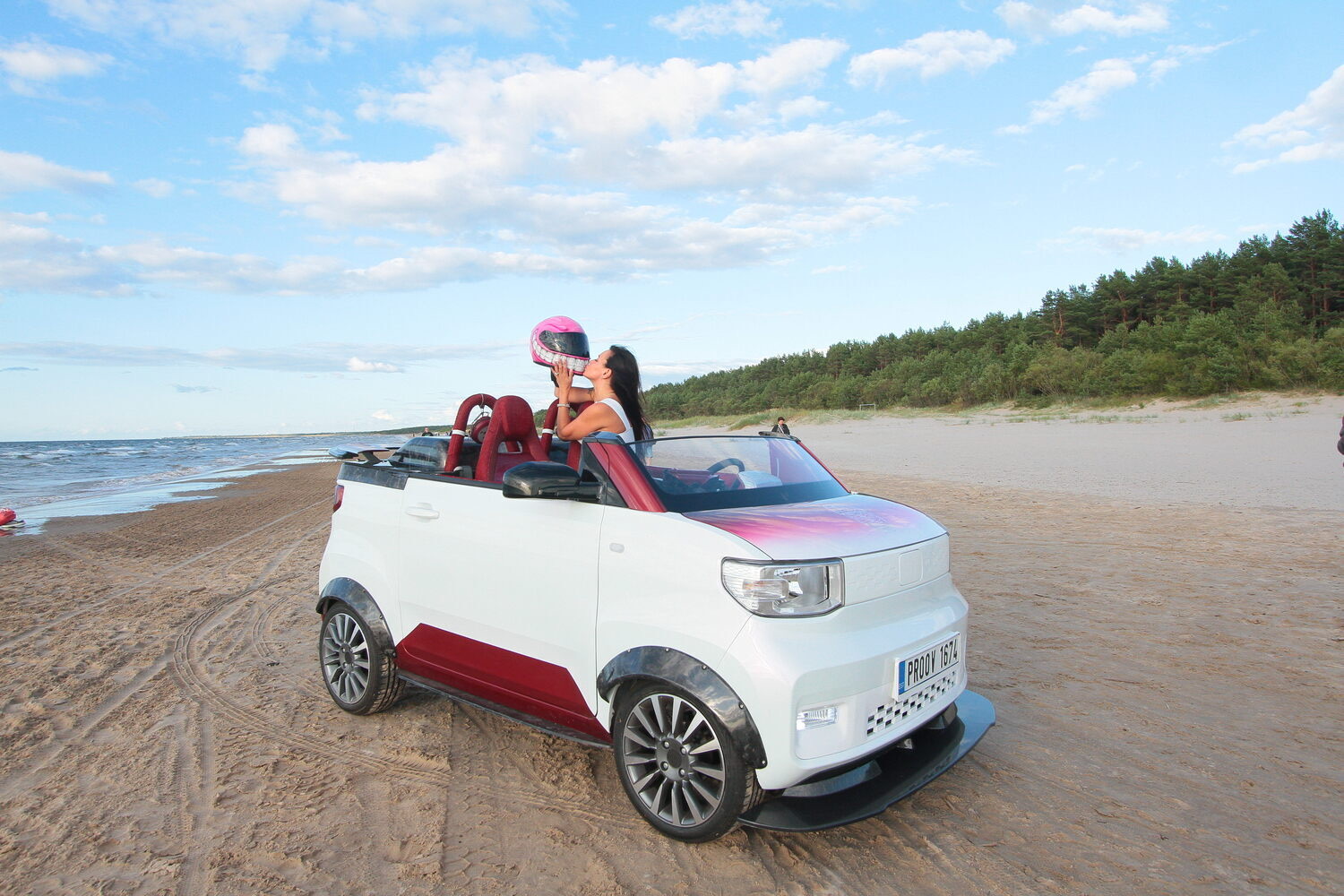 The white FreZe BeachStar EV roadster on a Baltic beach